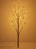 A decorative LED twig tree with warm white lights against a plain, warm-toned background. Produktbild-Vorschau