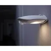 A white LED light fixture with a motion sensor is mounted on a gray wall. Voir les images du produit