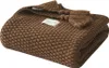 A folded brown knitted blanket with tassels and a small white label. Anteprima dell’immagine prodotto