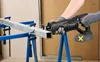 A person is using a reciprocating saw to cut a metal beam supported by sawhorses. Produktbild-Vorschau