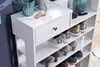 A white shoe rack with multiple shelves and a drawer, holding various shoes and some decorative items on top. Produktbild-Vorschau