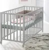 A baby crib with bedding is shown in a room. Produktbild-Vorschau