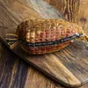 A netted meat product on a wooden cutting board. Produktbild-Vorschau