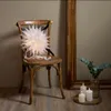 A white paper star decoration is placed on a wooden chair next to a large mirror and three lit candles. Podgląd zdjęcia produktu