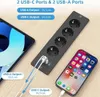 A power strip with USB ports is shown on a wooden table next to a tablet and a smartphone. Anteprima dell’immagine prodotto