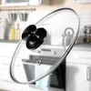 A close-up of a pot lid handle with a blurred kitchen background. Podgląd zdjęcia produktu