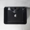 A black rectangular sink with a matte finish is shown from a top-down view, placed on a marble-like surface. Podgląd zdjęcia produktu