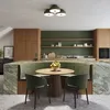 A modern kitchen with a built-in green banquette seating area around a round wooden table. Produktbild-Vorschau