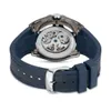 The back of a watch with a transparent case showing the internal mechanism, attached to a blue strap. Produktbild-Vorschau