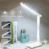 A white LED desk lamp is shown on a desk with books and a pen holder. Produktbild-Vorschau