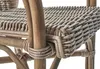 A close-up view of the woven rattan seat and frame of a chair. Podgląd zdjęcia produktu