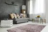 A living room scene with a sofa, coffee table, and rug. Produktbild-Vorschau