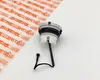 A STIHL oil tank cap with a tether is shown on a white background next to packaging with the STIHL logo. Produktbild-Vorschau