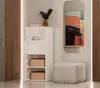 A modern entryway or living area with a white storage cabinet, a decorative mirror, and a soft ottoman. Náhľad obrázku produktu