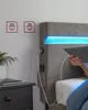 A close-up view of a bed with a person holding a tablet, showing integrated charging ports and LED lighting. Náhled obrázku produktu