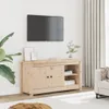 A wooden TV stand with a television mounted on the wall above it, in a room with a plant and curtains. Náhľad obrázku produktu