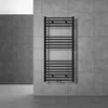 A black towel radiator mounted on a grey tiled wall in a modern bathroom setting. Náhled obrázku produktu