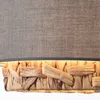 A close-up view of the bottom part of a pendant lamp, showing the woven water hyacinth shade and the fabric shade above. Produktbild-Vorschau