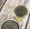 A bowl of dried monk pepper berries next to a glass of monk pepper berry tea. Produktbild-Vorschau