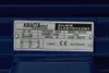 A close-up of a metal nameplate on a blue industrial machine. Voir les images du produit