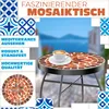 A mosaic bistro table with a cup of coffee on it, set against a blurred background of a seaside town. Produktbild-Vorschau