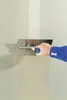 A person is using a trowel to apply plaster to a wall. Produktbild-Vorschau