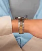 A close-up shot of a man's wrist wearing a silver and gold watch. Podgląd zdjęcia produktu