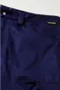 A close-up view of dark blue work pants, showing a pocket and a brand logo. Produktbild-Vorschau