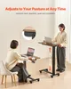 Two people using adjustable height laptop tables in a room. Produktbild-Vorschau