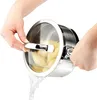 Hands are holding a pot with a glass lid, draining water from it. The pot contains some food item, possibly pasta or vegetables. Náhled obrázku produktu