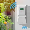 A white wireless weather station is mounted on a wall next to a plant with orange fruits. Podgląd zdjęcia produktu