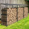A metal firewood rack filled with logs, placed outdoors on grass next to a wooden fence. Podgląd zdjęcia produktu