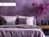 A bedroom scene with a bed dressed in purple bedding, a purple wall, and a decorative plant. Produktbild-Vorschau