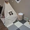 A child's play tent and toy storage basket are set up on a foam mat in a room. Produktbild-Vorschau