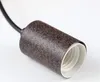 A close-up shot of a light socket with a speckled brown metal casing and a white interior. Anteprima dell’immagine prodotto