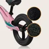 Close-up view of the rear wheel and frame of a pink balance bike, with magnified insets showing the tire tread and grip texture. Produktbild-Vorschau