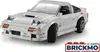 A white Lego-style model of a Mazda FC3S RX-7 car is shown from a front-three-quarter angle against a white background. The car has pop-up headlights and a license plate. Produktbild-Vorschau