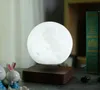 A levitating moon lamp on a wooden base, with decorative bunnies and books in the background. Produktbild-Vorschau