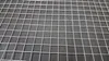 A close-up, overhead view of a silver wire mesh grid. Voir les images du produit