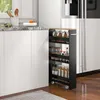 A narrow, multi-tiered storage cart filled with jars of spices and other kitchen items is positioned next to a white kitchen cabinet and a refrigerator. Podgląd zdjęcia produktu