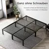A black metal bed frame is shown in a room with a shelf unit and a plant. Voir les images du produit