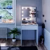 A vanity table with LED lighting and makeup accessories in a room with a window. Náhľad obrázku produktu