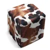 A cube-shaped ottoman with a cowhide pattern. Podgląd zdjęcia produktu