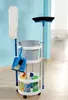 A cleaning cart with various cleaning supplies, including a mop, broom, dustpan, bucket, and cleaning bottles, is shown in a room with a light blue wall. Produktbild-Vorschau