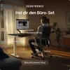 A person is using a standing desk and ergonomic chair in a home office setting. Voir les images du produit