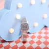 A silver digital watch is placed in front of a light blue cloud-shaped decoration with lights. Anteprima dell’immagine prodotto