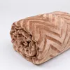 A rolled-up brown blanket with a chevron pattern is shown against a white background. Podgląd zdjęcia produktu