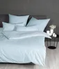 A neatly made bed with striped bedding and pillows. Voir les images du produit
