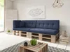 A modern living room with a blue pallet sofa, a geometric wall art, and a wooden coffee table. Produktbild-Vorschau