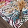A close-up of a colorful rug with a vase of dried grass. Podgląd zdjęcia produktu